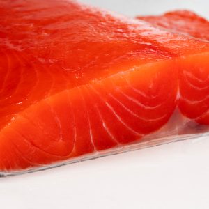 A close up of an uncooked sockeye salmon fillet from the side.