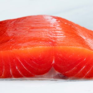 A close up of an uncooked sockeye salmon fillet from the side.