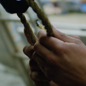 Close up of hands mending a fishing net.