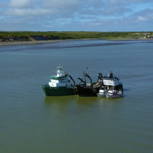 Two large boats and two smaller boats floating in Bristol Bay.